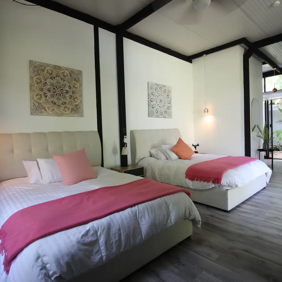 Habitación amplia con dos camas y acceso al jardín