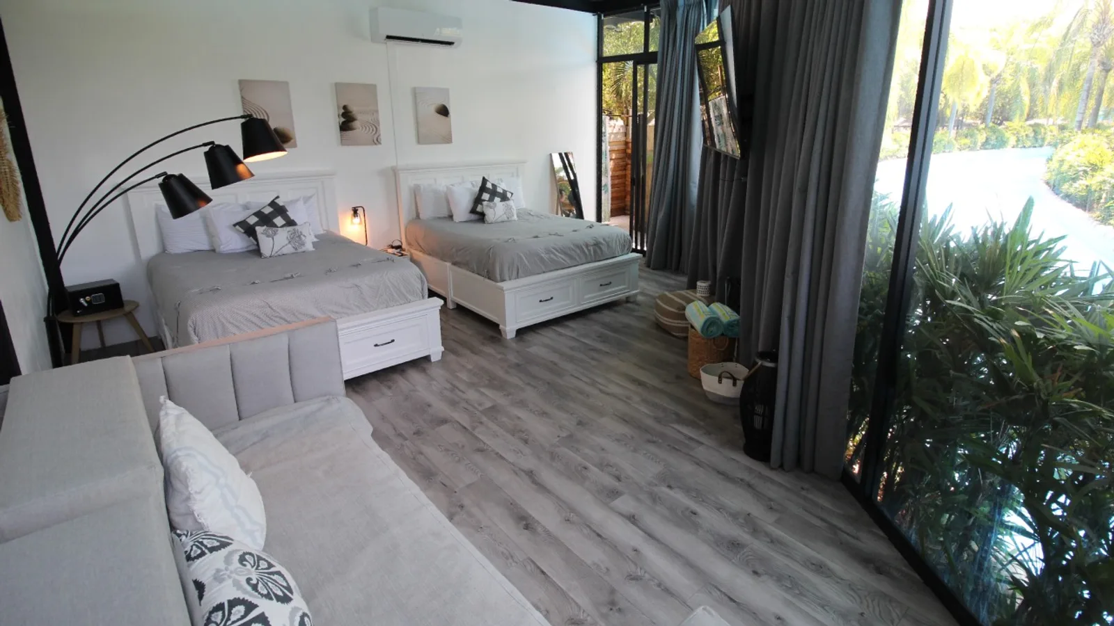 Habitación de la Suite VIP con dos camas, sala y ventanales frente al jardín